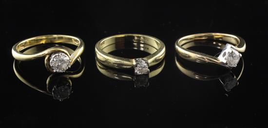 Three modern 18ct gold and solitaire diamond rings, sizes K & M(2).